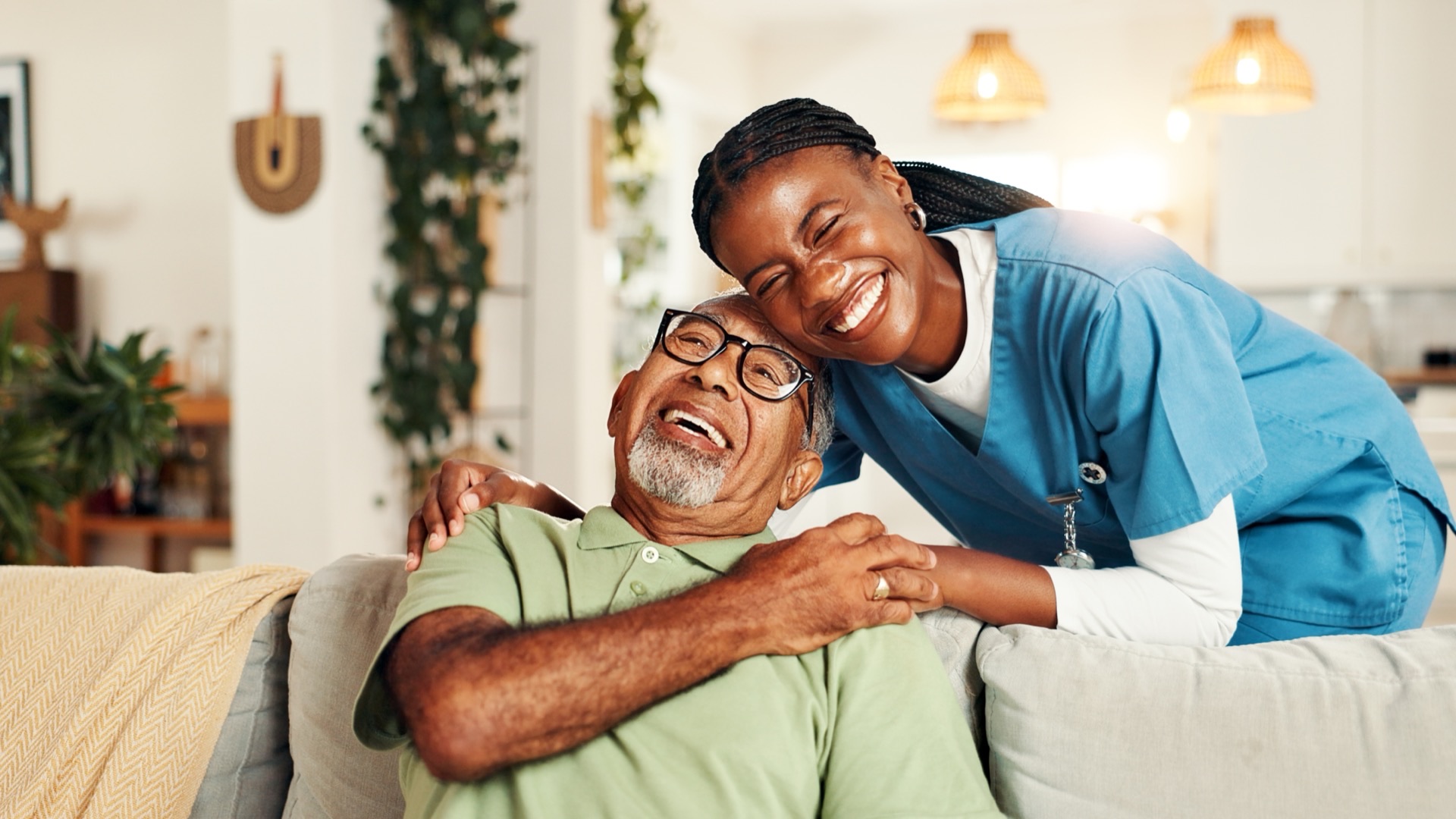 Caregiver and elderly patient laughing together in long-term care setting